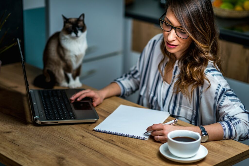 Young woman drinking coffee and working at home